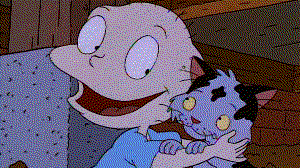 A screenshot of a Rugrats episode; Tommy Pickles is holding a purple kitten with black spots.